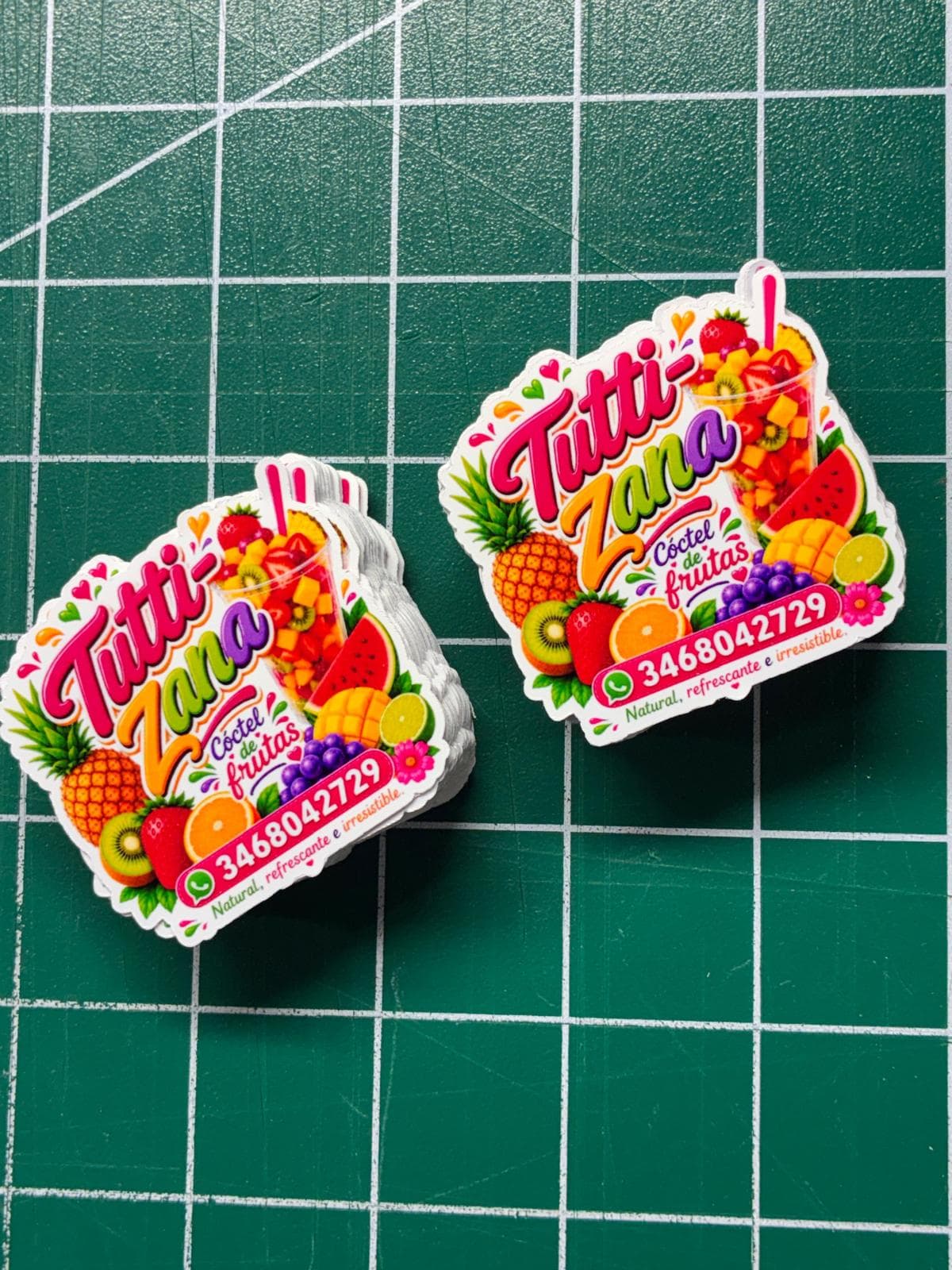 Stickers troquelados coloridos de Tutti-Zana sobre tapete verde