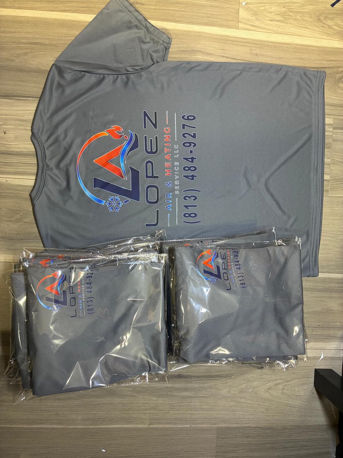Camisa gris de Lopez Air & Heating junto a camisas empacadas