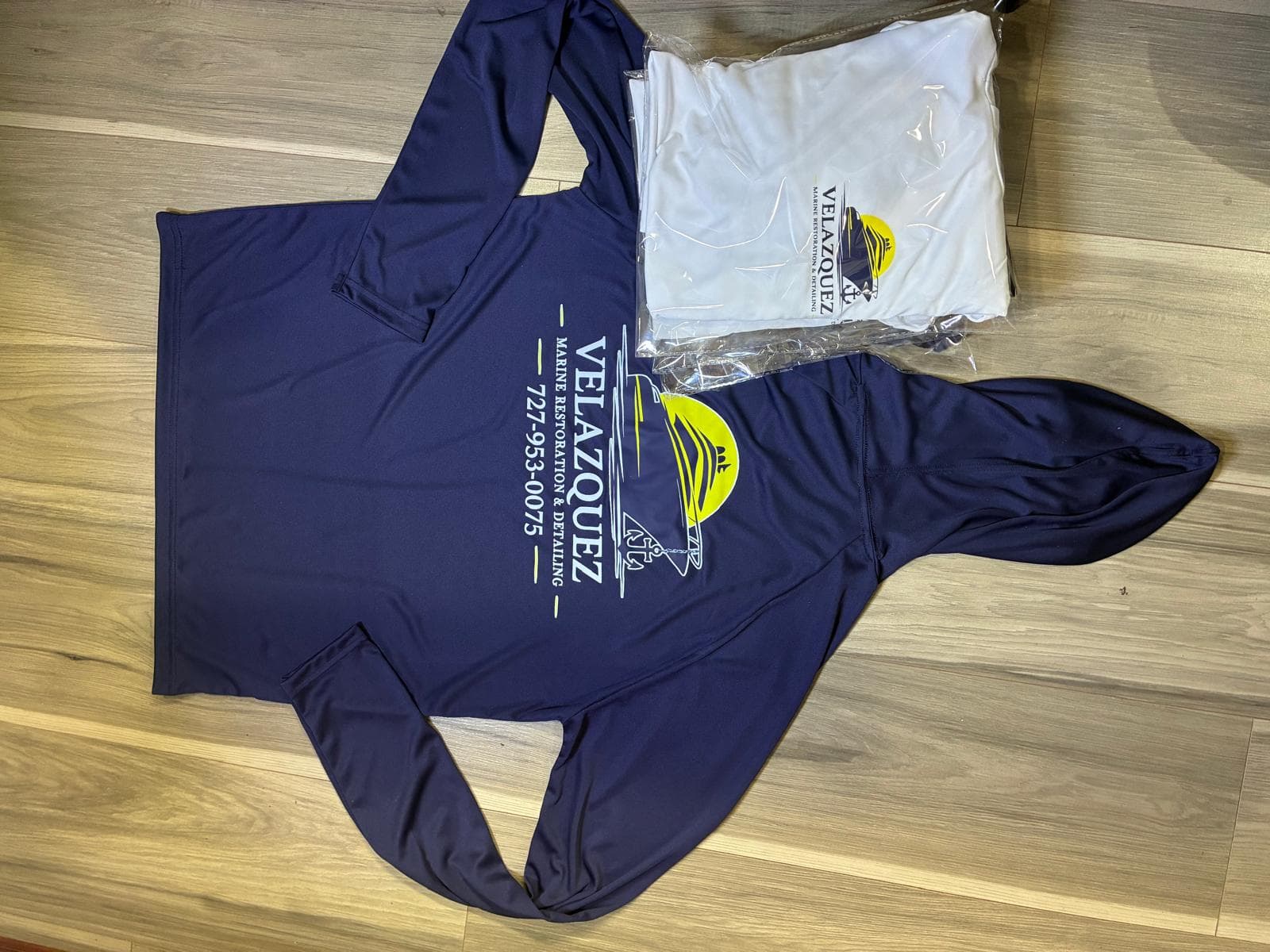 Sudadera azul marino de Velazquez Marine Restoration y camisas empacadas