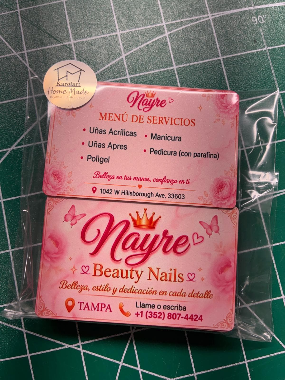 Tarjetas rosadas de Nayre Beauty Nails sobre tapete de corte